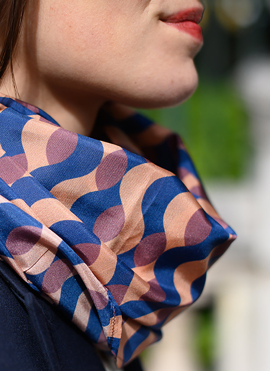 Foulard en soie 118 Meilleur Ami Paris, porté femme, vue de près. Jeu graphique coloré, bordeaux, bleu nuit et vieux rose.