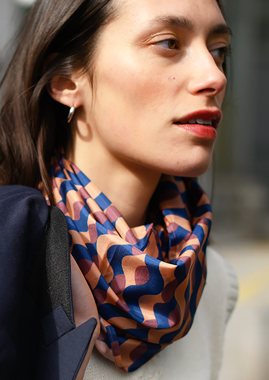 Foulard en soie 118 Meilleur Ami Paris, porté femme. Jeu graphique coloré, bordeaux, bleu nuit et vieux rose.