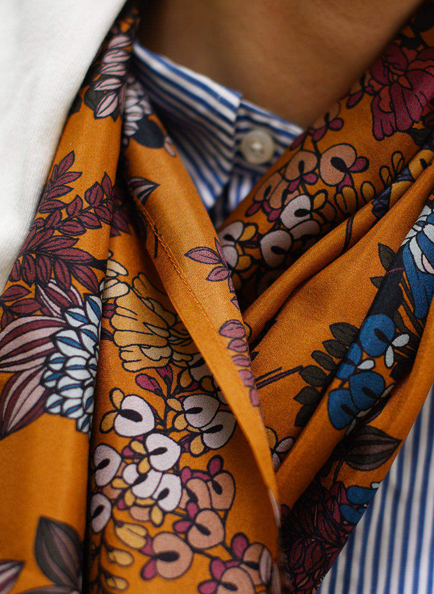 Foulard en soie 77 Meilleur Ami, porté femme dénoué. Fleurs colorées sur fond caramel.