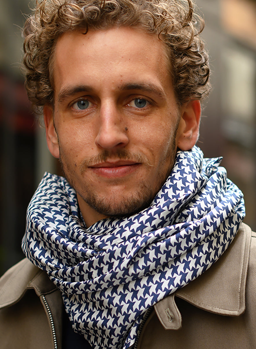 Foulard en soie 84 Meilleur Ami Paris, porté homme. Motifs pied-de-coq bleu marine et blanc.