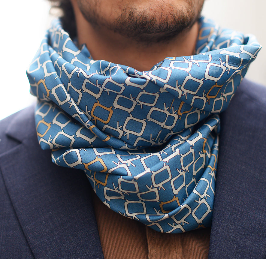 Foulard en soie 85 Meilleur Ami Paris, porté homme. Gros plan sur les motifs graphiques en blanc sur fond bleu.