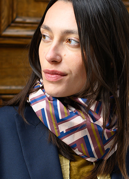 Foulard en soie 116 Meilleur Ami, porté femme. Une rayure géométrique aux coloris bordeaux, or , blanc et bleu nuit. 