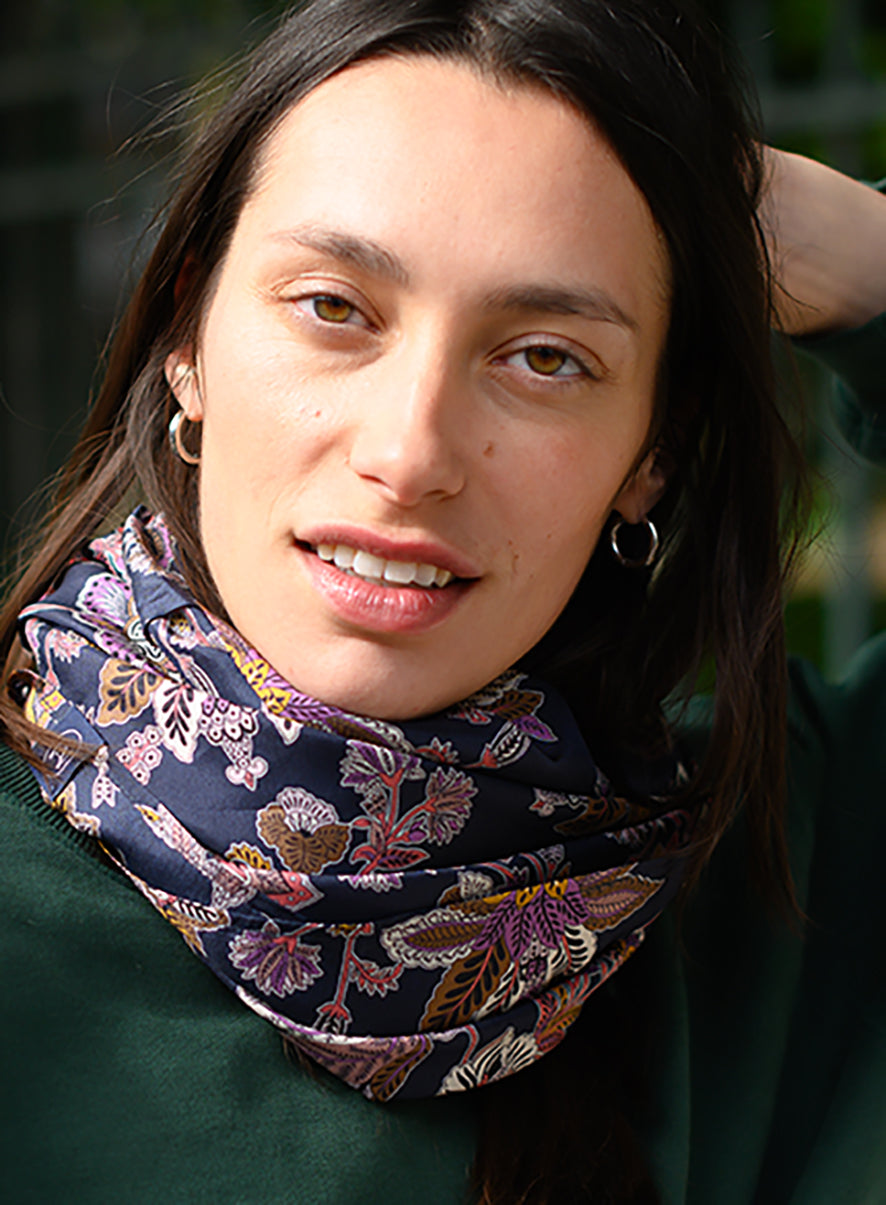 Comme un batik revisité, ces fleurs s'épanouissent sur un fond bleu nuit. Foulard en soie 120 Meilleur Ami, porté femme.