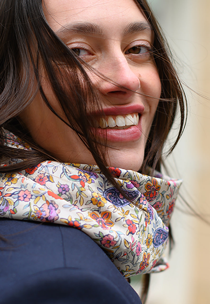 Foulard en soie Meilleur Ami Paris, porté femme. Des fleurs colorées sur un fond blanc crème, dans l'esprit d'un jardin anglais. 